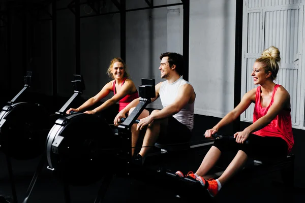 Entrenamiento de amigos en la máquina de remo —  Fotos de Stock