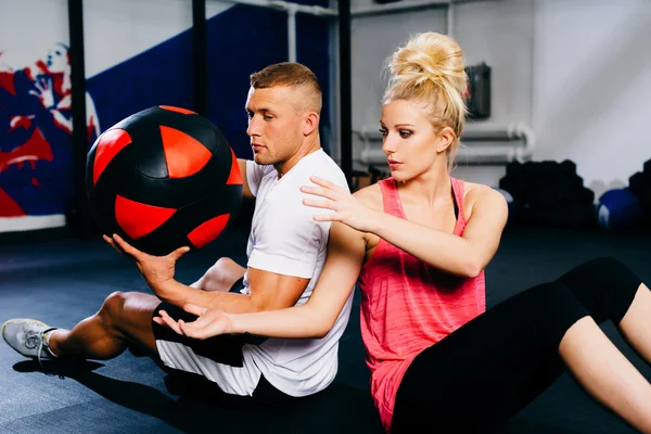 Pár s míčem trénink v tělocvičně — Stock fotografie