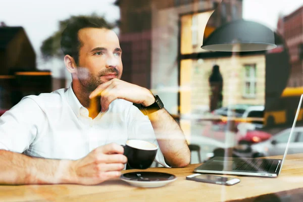 Hombre guapo mirando por la ventana — Foto de Stock