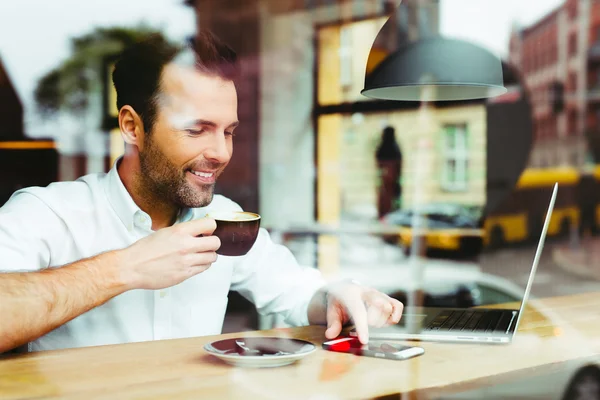 Ung man på café med smartphone — Stockfoto