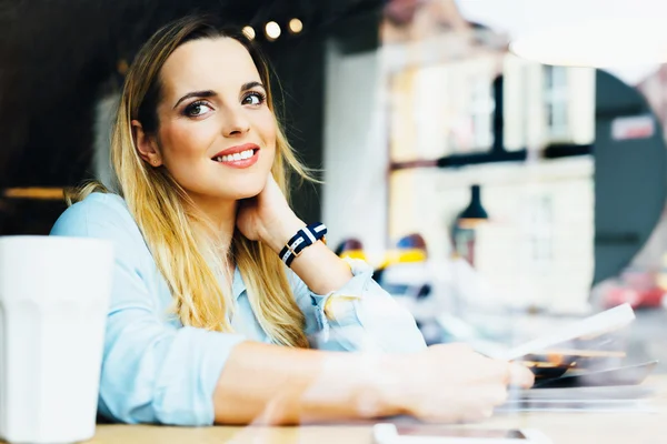 Schöne junge Frau sitzt im Café — Stockfoto