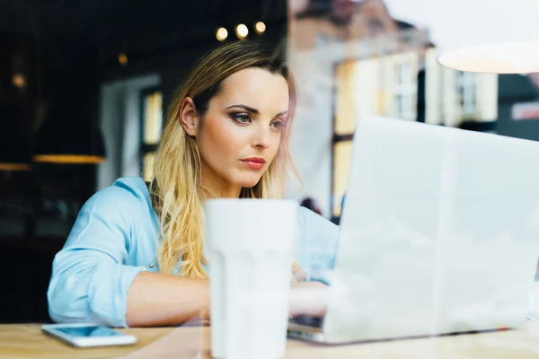 Vrouw die op laptop in café werkt — Stockfoto