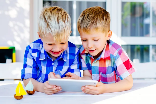 Two brothers playing on digital tablet