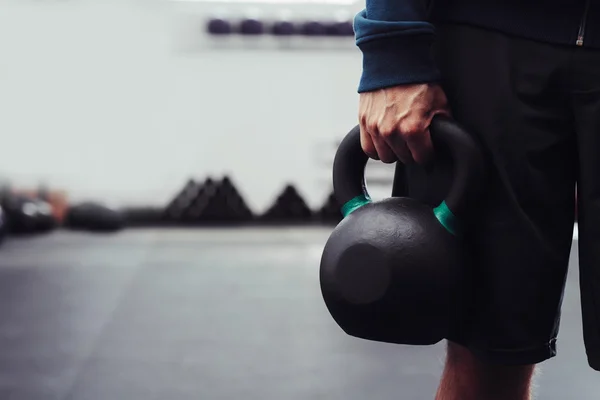 Man holding heavy kettlebell — Stock Photo, Image