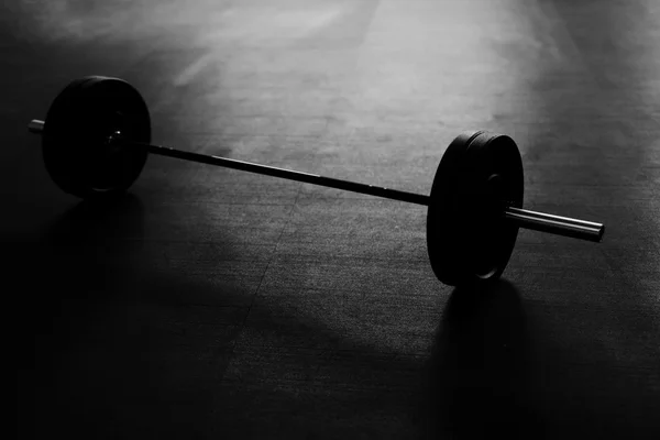 Barbell on gym floor — Stock Photo, Image