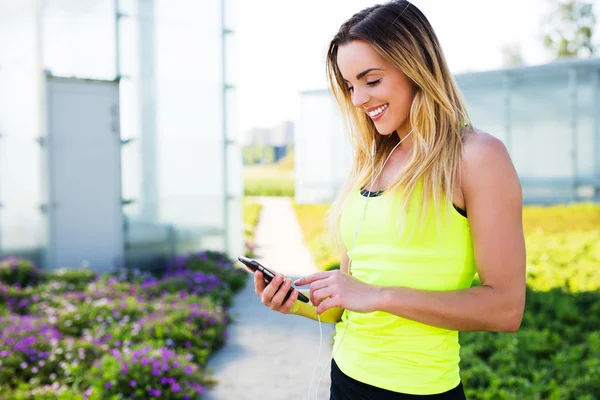 Läuferin überprüft ihr Smartphone — Stockfoto