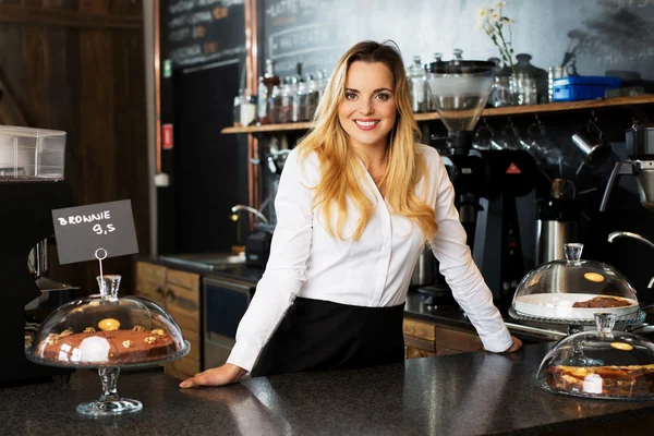 Cheerful waitress standing behind the bar — Stock Photo, Image