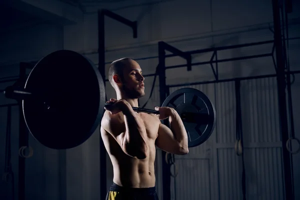 Uomo che solleva bilancieri in palestra — Foto Stock