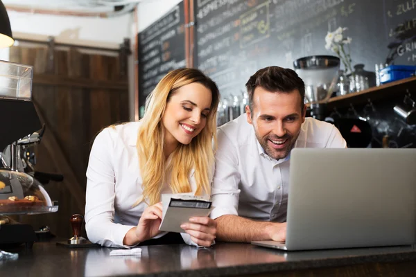 Two cafe managers working on laptop — Stock Photo, Image