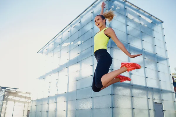 Joven corredor femenino saltando alto — Foto de Stock