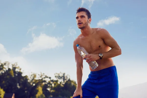 Běžec odpočívá s lahví vody — Stock fotografie