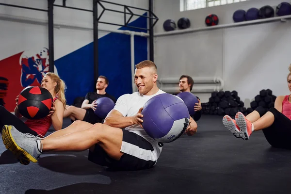 Pessoas treinando com bola de exercício no ginásio — Fotografia de Stock