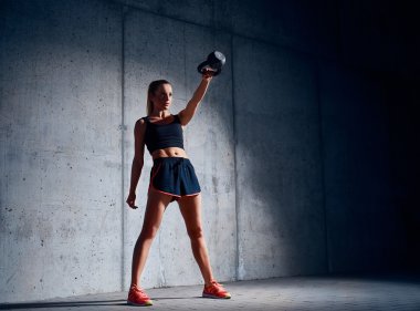 kadının kettlebell salıncak egzersiz yapması