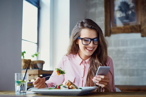 Молода жінка їсть салат в ресторані — стокове фото