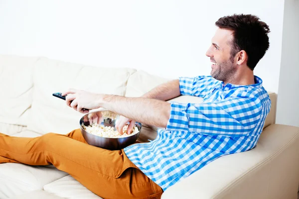 Man kanaal hoppen op een sofa — Stockfoto