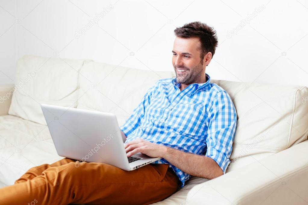 Happy handsome man sitting on a sofa