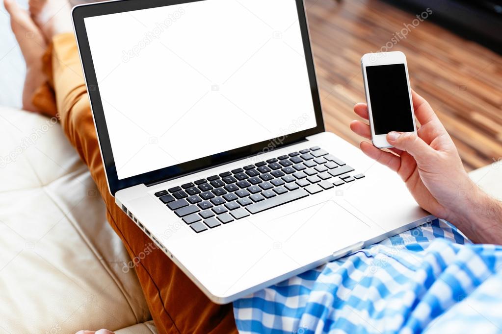 person holding a mobile and a laptop