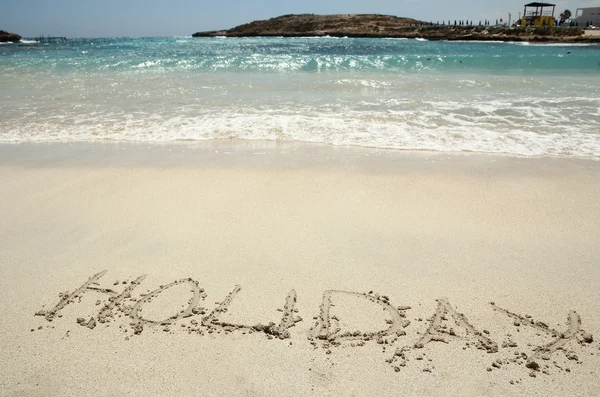 Una palabra "vacaciones" en la orilla del mar — Foto de Stock