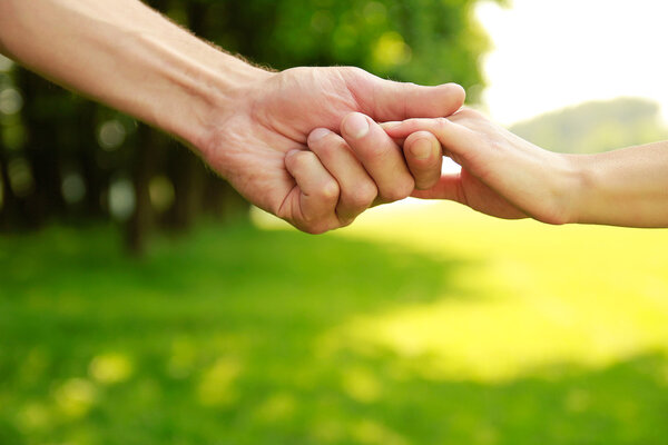 parent holds hand of child  