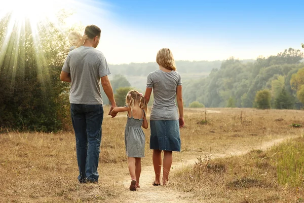 Caminhada jovem família — Fotografia de Stock