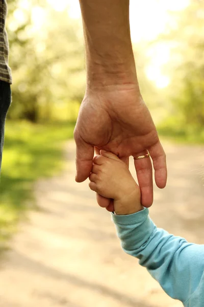 Ouder houdt de hand van een klein kind — Stockfoto