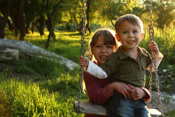 Happy children on a swing — Stock Photo, Image
