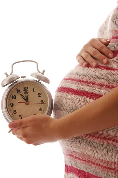Беременная женщина с часами — стоковое фото