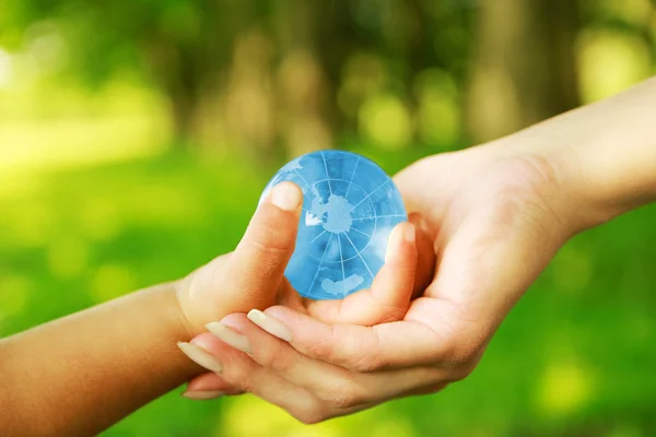 Glass globe in hands — Stock Photo, Image