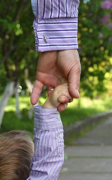 Родитель держит за руку маленького ребенка — стоковое фото