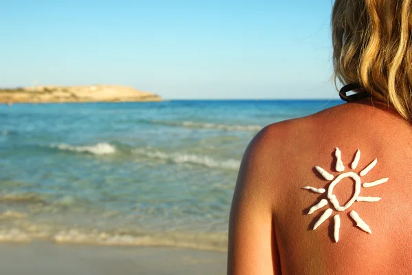 De crema solar en la espalda femenina — Foto de Stock