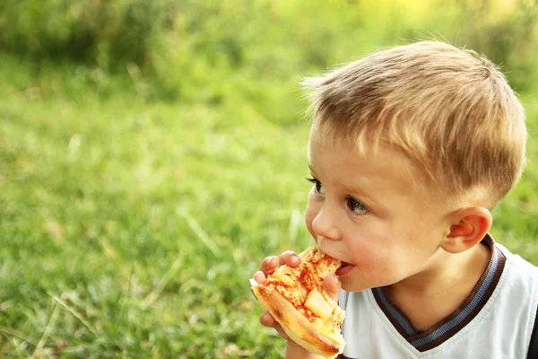 Gyermek ízletes pizzát eszik — Stock Fotó