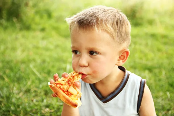 Criança comendo pizza saborosa — Fotografia de Stock