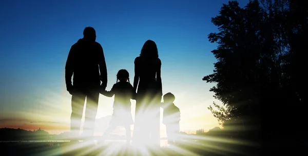 Baba, anne ve iki çocuğu siluetleri — Stok fotoğraf