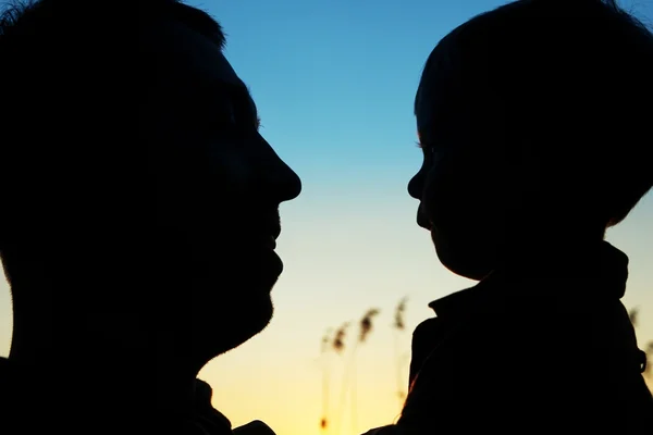 Silhouetten von Eltern mit Baby — Stockfoto