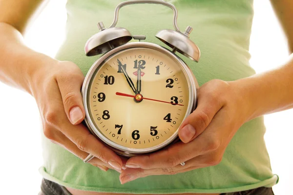 Jovem grávida com despertador — Fotografia de Stock