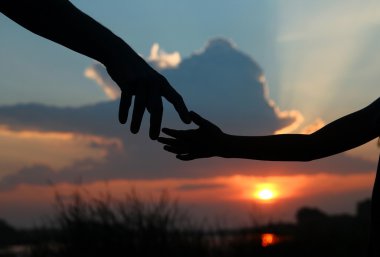 Siluetleri ebeveyn çocuk elini tutar
