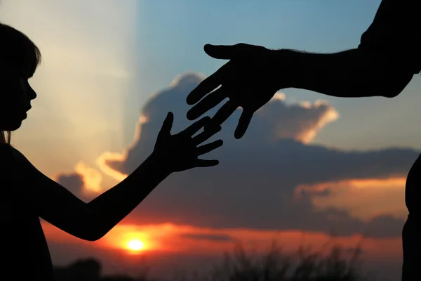 Siluetleri ebeveyn çocuk elini tutar — Stok fotoğraf