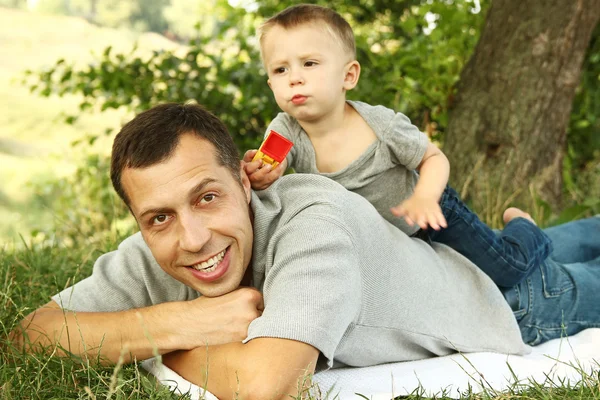 Pappa och son på naturen spelar i park — Stockfoto