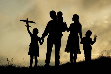 Doğuştan çocuklu mutlu bir ailenin silueti.