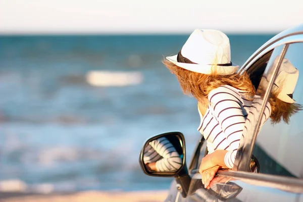 休暇旅行で自然の中で海によって車の中で幸せな女の子 — ストック写真