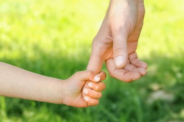 Mutlu bir geçmişi olan çocuğun elini tutan ebeveyn.