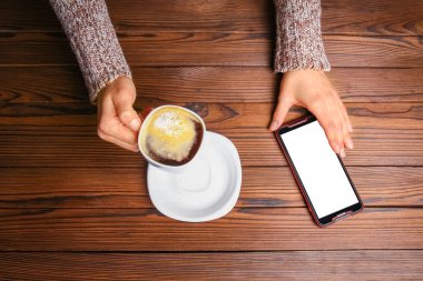 Kadın eli ve kahve ahşap arka planda.