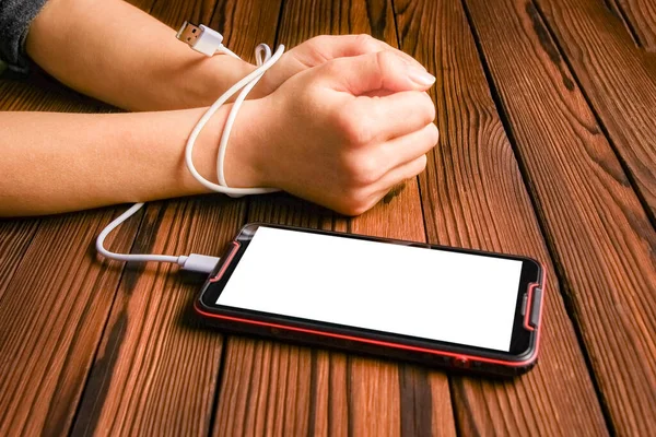 phone with hands addiction on a wooden background