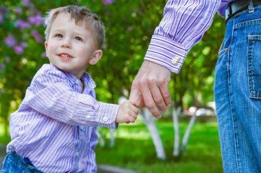Mutlu bir geçmişi olan çocuğun elini tutan ebeveyn.