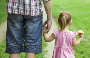 Ebeveyn küçük bir çocuğun elini tutar.