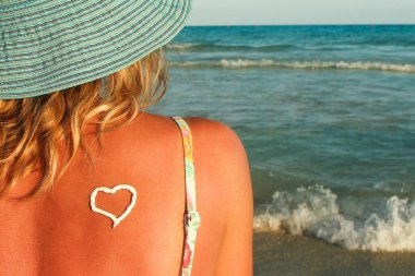 Yazın bir kadının omzunda güneş kremi.  