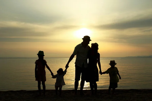 happy family silhouette at sunset by the sea