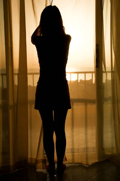 ホテルの窓の近くの女性の素敵なシルエット — ストック写真