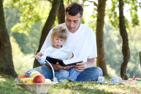 Młody Ojciec Szczęśliwą Córką Czytającą Biblię Pikniku — Zdjęcie stockowe