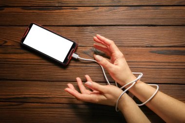 Telefon ahşap bir arka planda el bağımlılığı